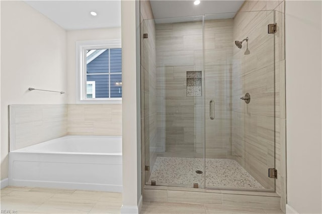 full bathroom with tile patterned flooring, a garden tub, and a shower stall