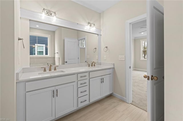 full bathroom with a sink, baseboards, and double vanity