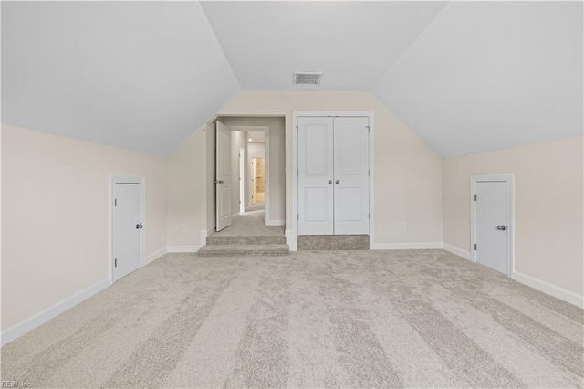 additional living space featuring baseboards, lofted ceiling, visible vents, and carpet flooring