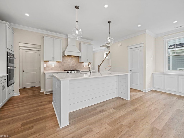 kitchen with double oven, custom exhaust hood, crown molding, and visible vents