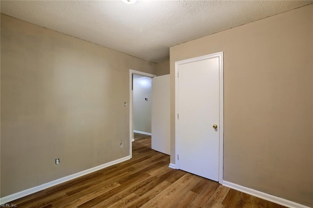 unfurnished bedroom with hardwood / wood-style flooring and a textured ceiling