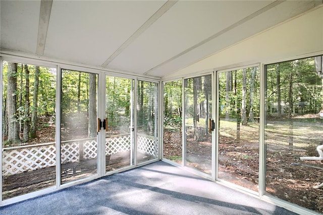 unfurnished sunroom featuring vaulted ceiling with beams and plenty of natural light