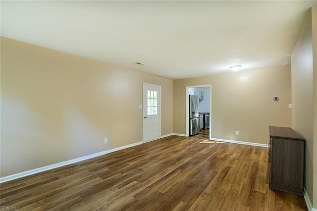 unfurnished room with dark hardwood / wood-style flooring