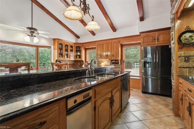 kitchen featuring appliances with stainless steel finishes, light tile patterned floors, beamed ceiling, decorative light fixtures, and sink