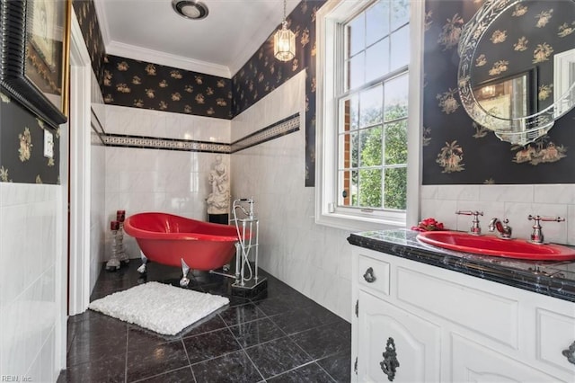 bathroom with vanity, a tub to relax in, crown molding, and tile walls