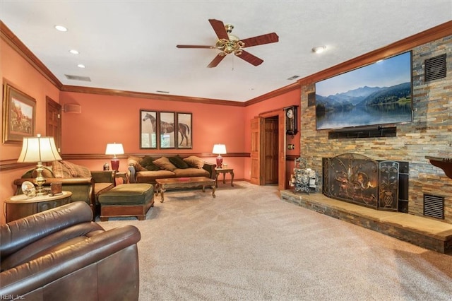 carpeted living room featuring ceiling fan, crown molding, and a stone fireplace