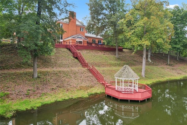 view of dock with a gazebo and a deck with water view