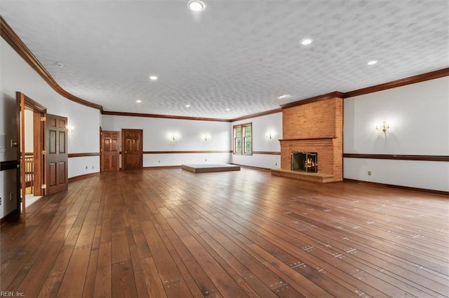 unfurnished living room with ornamental molding, wood-type flooring, a textured ceiling, and a fireplace