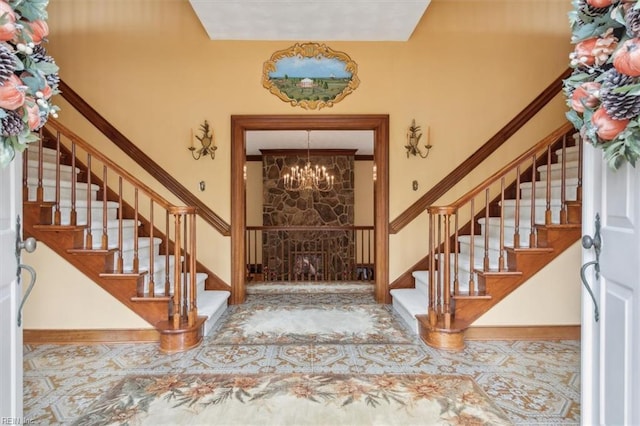 foyer entrance with ornamental molding and a chandelier