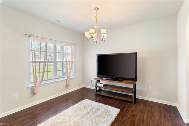 living room with dark hardwood / wood-style floors and a notable chandelier