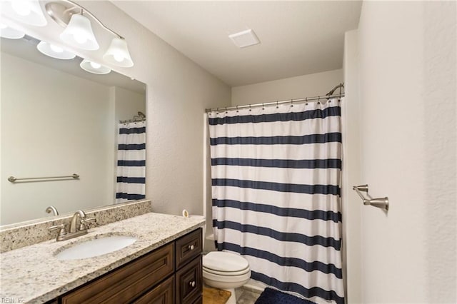 bathroom with curtained shower, vanity, and toilet