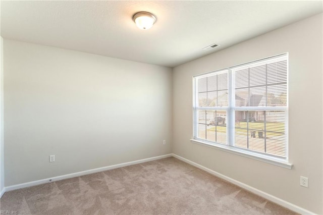 spare room featuring light colored carpet