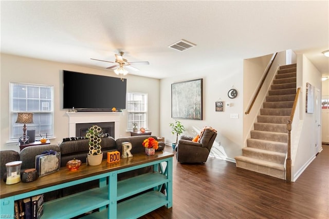 living room featuring ceiling fan and dark wood-type flooring