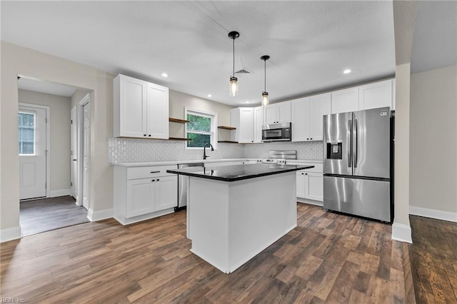 kitchen featuring white cabinetry, stainless steel appliances, and decorative light fixtures