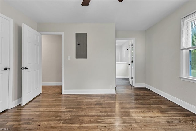 unfurnished room featuring ceiling fan, electric panel, and dark wood-type flooring