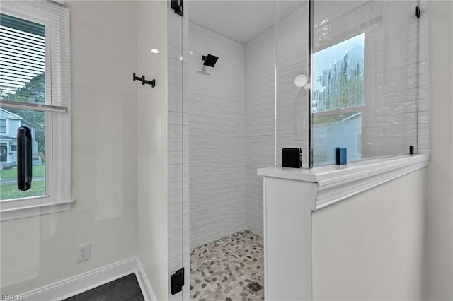 bathroom featuring plenty of natural light and tiled shower