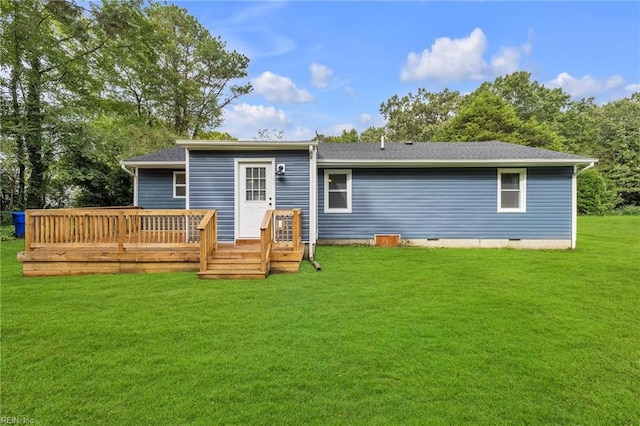 rear view of house with a lawn and a wooden deck