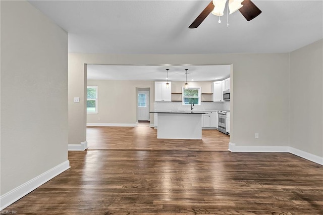 unfurnished living room with ceiling fan, dark hardwood / wood-style floors, and sink