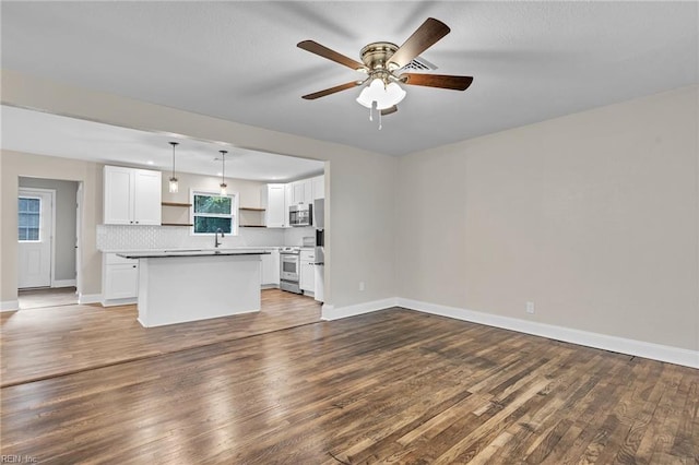 unfurnished living room with ceiling fan, hardwood / wood-style flooring, and sink