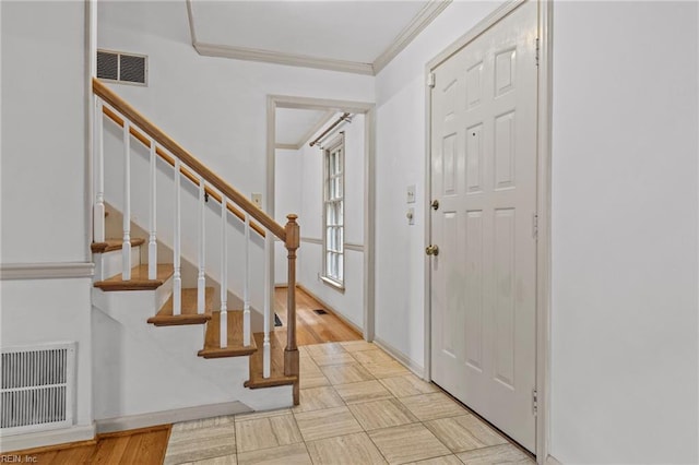 foyer entrance with light hardwood / wood-style flooring and crown molding