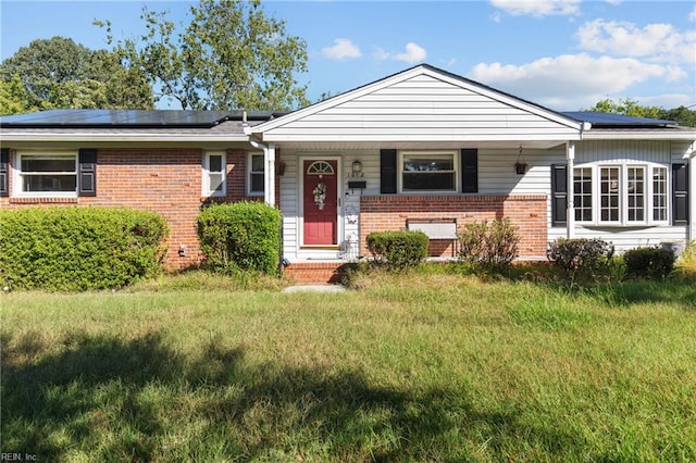 view of front of home featuring a front lawn, solar panels, and covered porch