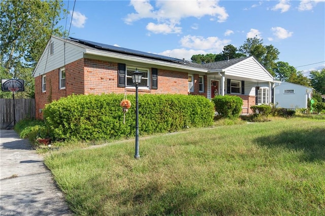 single story home with a front yard and solar panels