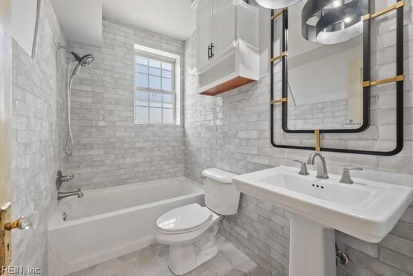 bathroom with tile walls, toilet, decorative backsplash, and tiled shower / bath combo