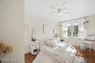 bedroom featuring dark wood-type flooring, ornamental molding, and ceiling fan