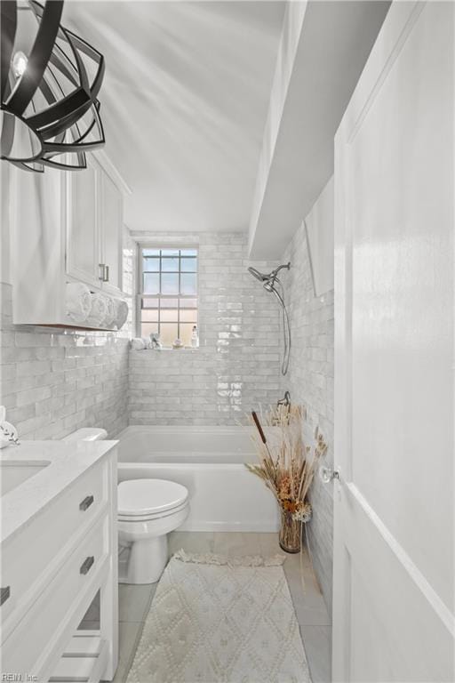 full bathroom featuring tiled shower / bath, toilet, vanity, and backsplash