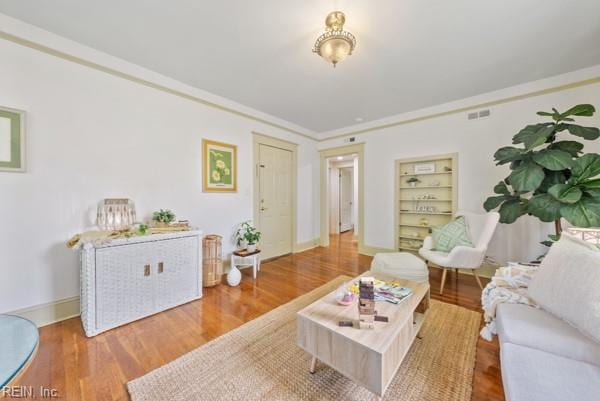 living room with wood-type flooring and crown molding