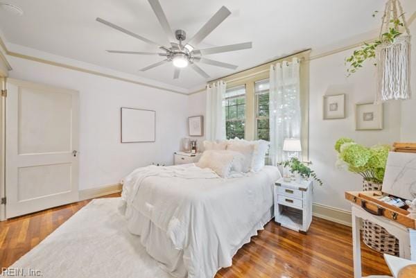 bedroom featuring dark wood-type flooring, ceiling fan, and crown molding