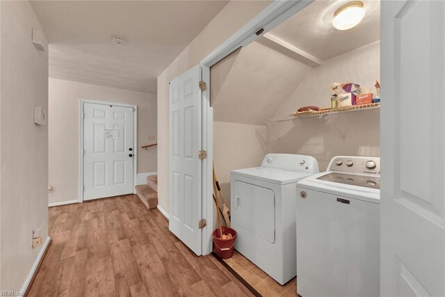 washroom with light hardwood / wood-style flooring and washer and clothes dryer