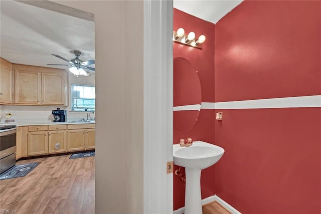 bathroom with hardwood / wood-style floors, ceiling fan, and sink