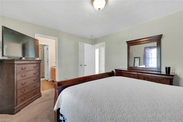 carpeted bedroom featuring ensuite bath