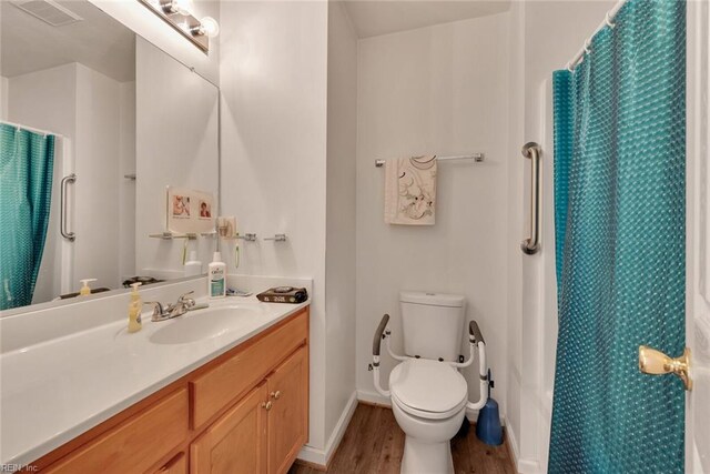 bathroom with a shower with curtain, hardwood / wood-style floors, vanity, and toilet