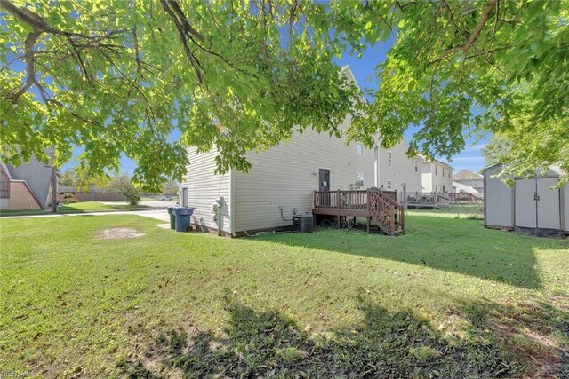 view of yard featuring a wooden deck and a storage unit