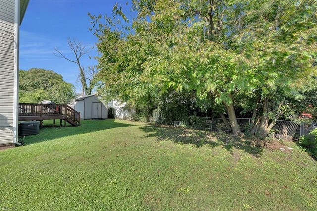 view of yard featuring a deck and a storage unit