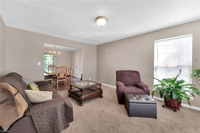 living room with light carpet and an inviting chandelier