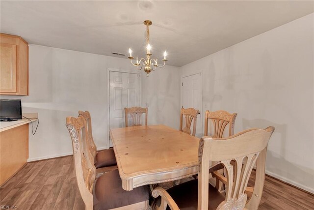 dining room featuring light wood-type flooring and a chandelier