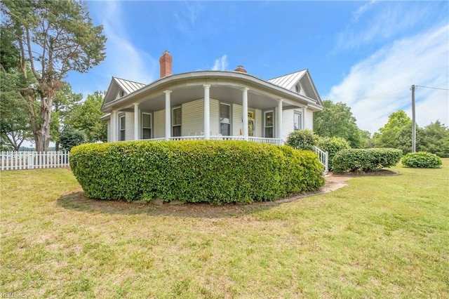 view of property exterior with a lawn and covered porch