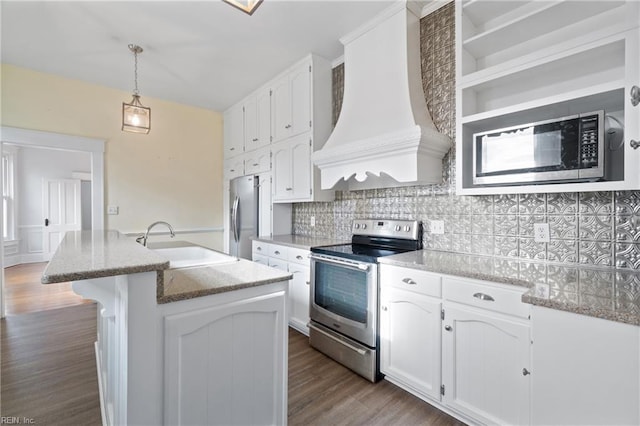 kitchen with appliances with stainless steel finishes, an island with sink, white cabinets, custom exhaust hood, and sink