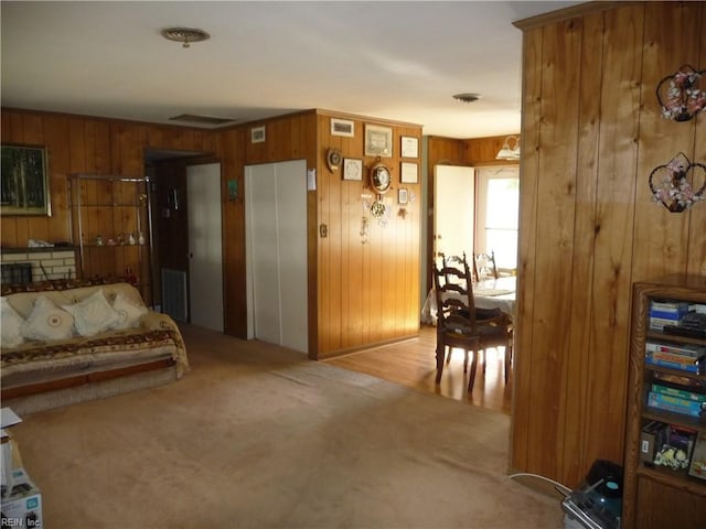 interior space with wooden walls, light colored carpet, and elevator