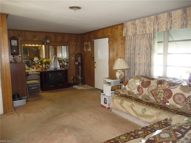 carpeted living room featuring wooden walls