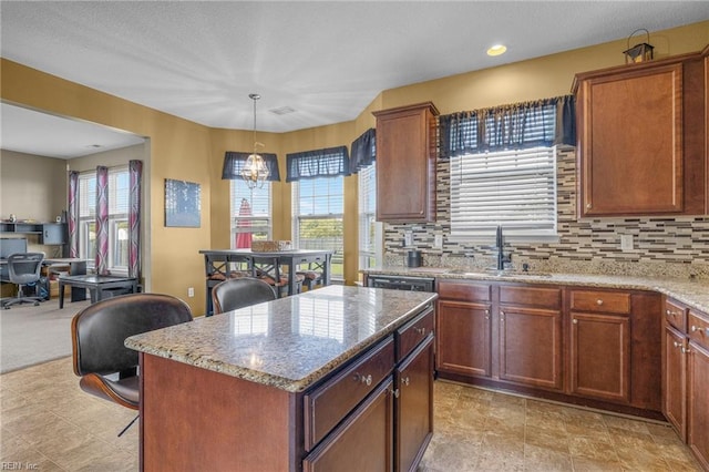 kitchen with decorative backsplash, a center island, hanging light fixtures, and sink