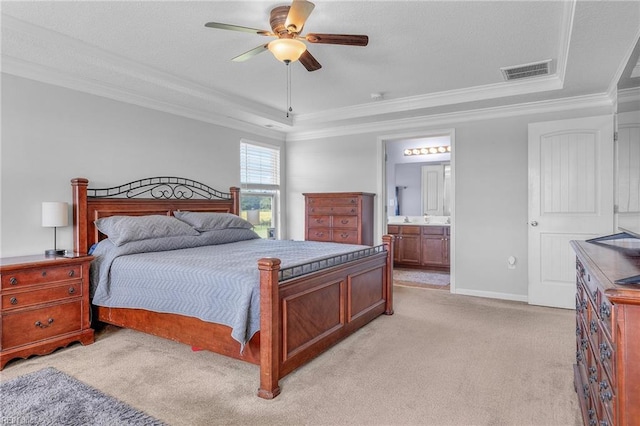 bedroom with light carpet, ensuite bath, ornamental molding, a raised ceiling, and ceiling fan