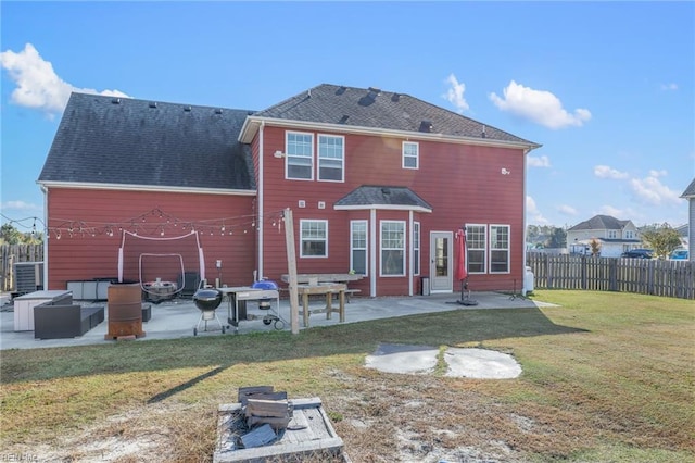 back of property featuring a lawn, a patio, and an outdoor fire pit