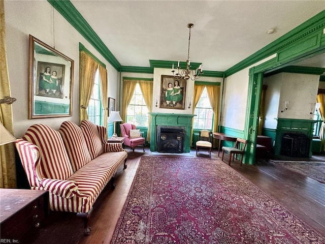 living area with ornamental molding, dark hardwood / wood-style floors, and a notable chandelier