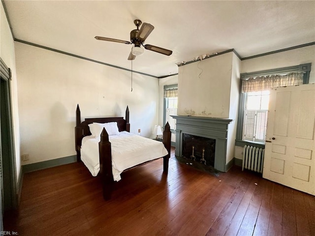 bedroom featuring multiple windows, radiator heating unit, ceiling fan, and ornamental molding