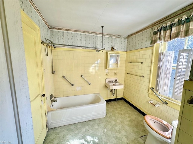 full bathroom with sink, toilet, shower / tub combination, and tile walls