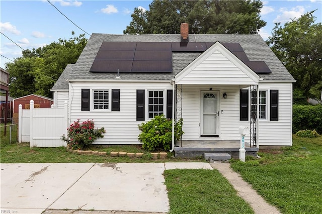 bungalow featuring a front lawn and solar panels